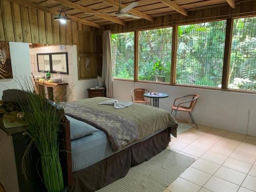 a bedroom with a bed in a room with windows at El Zota Hotel in Cariari