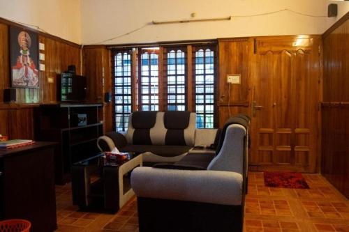 a living room with two chairs and a table at Texas Guest house in Trivandrum
