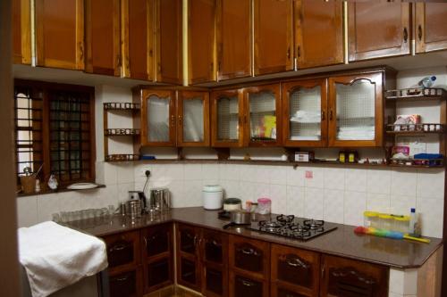 a kitchen with wooden cabinets and a counter top at Texas Guest house in Trivandrum