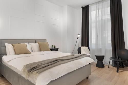 a white bedroom with a large bed and a window at VD Boutique Apartments No 2 in Bucharest