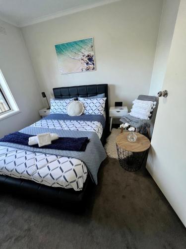 a bedroom with two beds and a table at 1 bed room - Cozy unit in Cheltenham