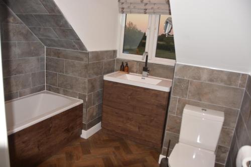 a bathroom with a tub and a sink and a toilet at The Bunkhouse - 2 bedroom home with parking in Worcester