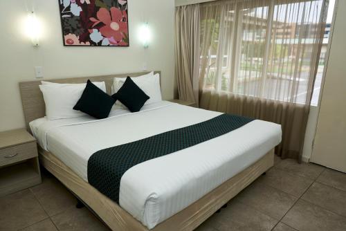 a bedroom with a large bed with a window at Ashwood Motel in Gosford