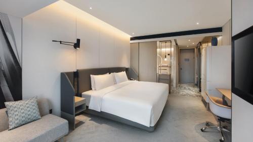 a bedroom with a large white bed and a desk at Crowne Plaza Quanzhou Riverview by IHG in Quanzhou