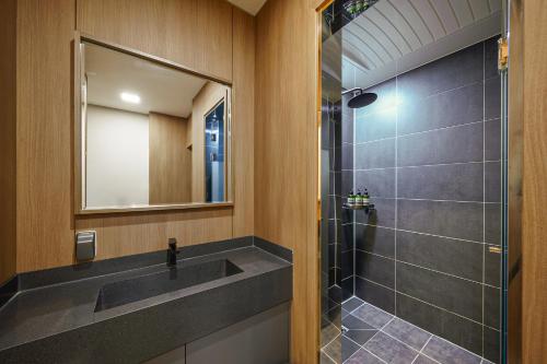 a bathroom with a sink and a shower at MTM Family Hotel in Gyeongju