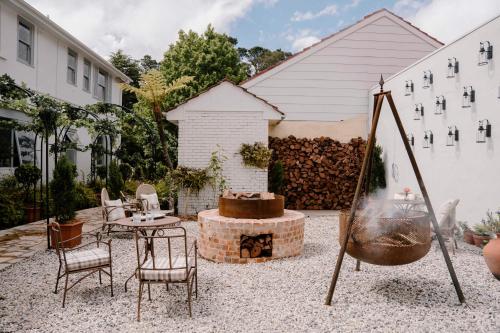 a patio with a table and chairs and a fire pit at Osborn House in Bundanoon