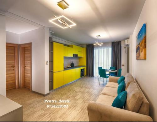 Una sala de estar con un sofá y una cocina. en Sunway - Pool & Spa Beach Resort, en Mamaia Nord – Năvodari