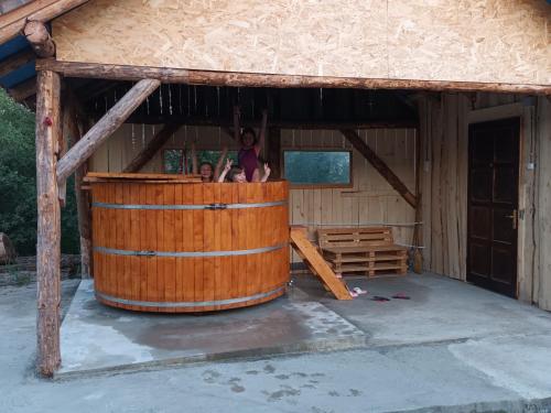 una gran bañera de madera en un edificio con gente dentro en Casa Rustic Fehér & Fekete Vendégházak en Sovata