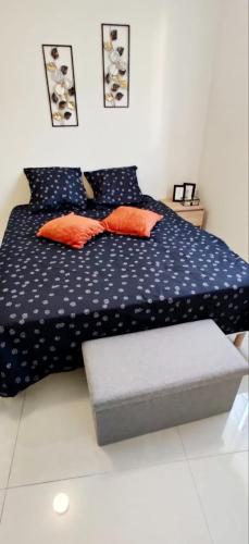 - une chambre avec un lit bleu et des oreillers orange dans l'établissement Le vernonnais Moderne, à Vernon