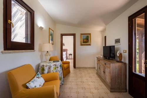 sala de estar con sillas amarillas y TV en Tenuta DonnAnna Agriturismo&Glamping en Galatone