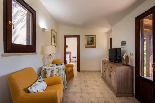 a living room with yellow chairs and a television at Tenuta DonnAnna Agriturismo&Glamping in Galatone