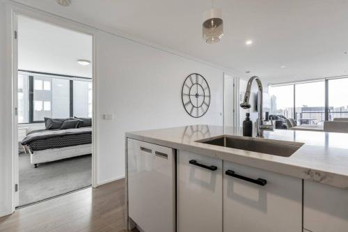 een witte keuken met spoelbak en een woonkamer bij Southbank Melbourne Gem in Melbourne