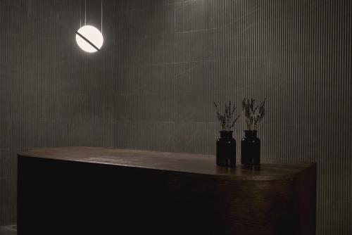 two black vases with flowers on a table in a room at Archipelagos All Suites in Elia Beach