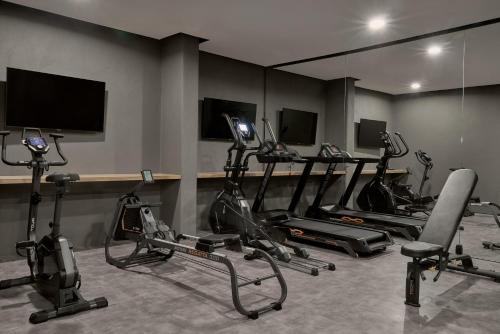 a gym with several exercise bikes and a flat screen tv at Archipelagos All Suites in Elia Beach