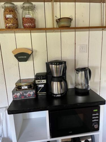 a counter with a coffee maker on top of a microwave at Fogdarps B&B -Eget gästhus- in Förslöv