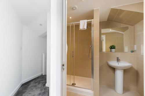 ein Bad mit einer Dusche und einem Waschbecken in der Unterkunft Skyvillion - 4 Bed Luxury Apartment with Balcony & Parking in Enfield