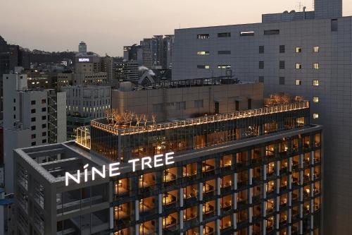 ein Baumschild auf einem Gebäude in der Unterkunft Nine Tree Premier Hotel Myeongdong 2 in Seoul