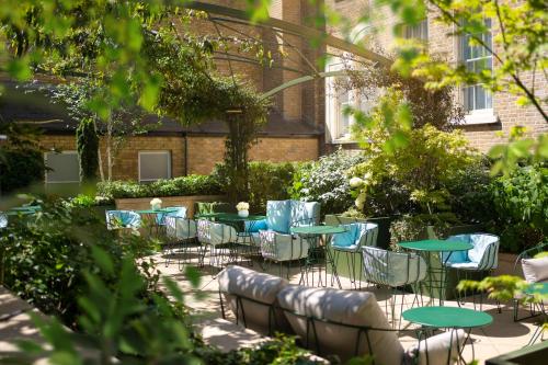 a group of tables and chairs in a garden at COMO Metropolitan London in London