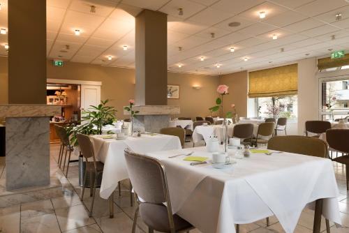 a dining room with white tables and chairs at Hotel Harheimer Hof in Frankfurt/Main