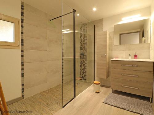 uma casa de banho com uma cabina de duche em vidro com um lavatório e um balcão em Gîte Nécy, 3 pièces, 4 personnes - FR-1-497-160 em Nécy