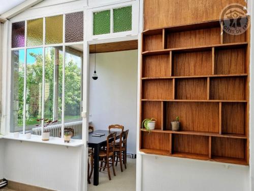 une cuisine et une salle à manger avec des étagères en bois dans l'établissement Gîte de charme à Cambrai : 3 chambres, jardin, garage, proche centre et gare - FR-1-510-178, à Cambrai
