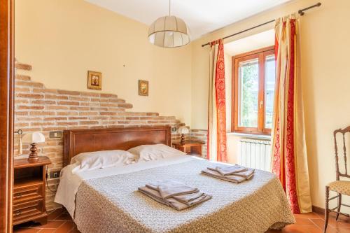 a bedroom with a bed with towels on it at Abadia Farneto in Gubbio