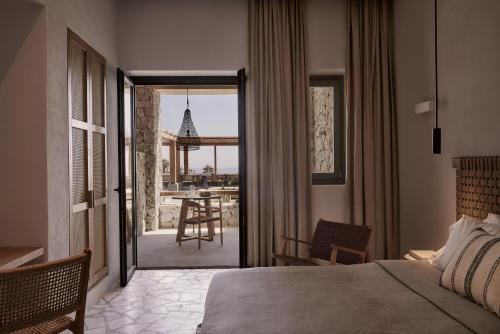 a bedroom with a bed and a view of a table at Archipelagos All Suites in Elia Beach