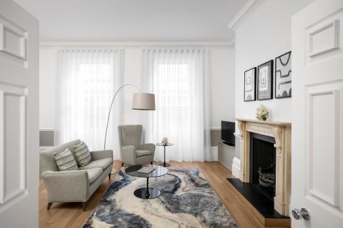 a living room with a couch and a fireplace at COMO Metropolitan London in London