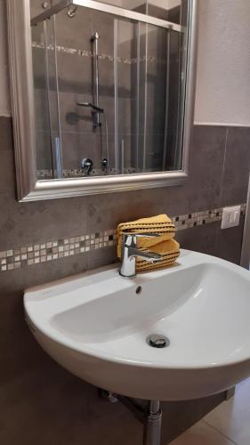 un lavandino bianco in un bagno con specchio di On the road a Telti