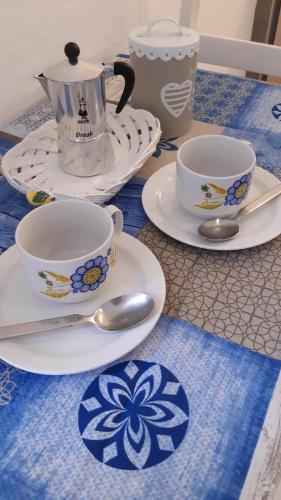 a table with plates and cups and spoons on it at On the road in Telti