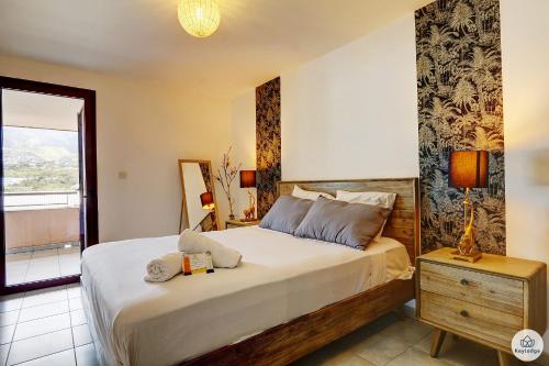 a bedroom with a large bed and a window at La Tonnelle - 42m2 - Terrasse - Sainte-Clotilde in Saint-Denis