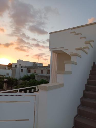 a stair case on the side of a building with a sunset at GIOSAHOUSE in Uggiano la Chiesa