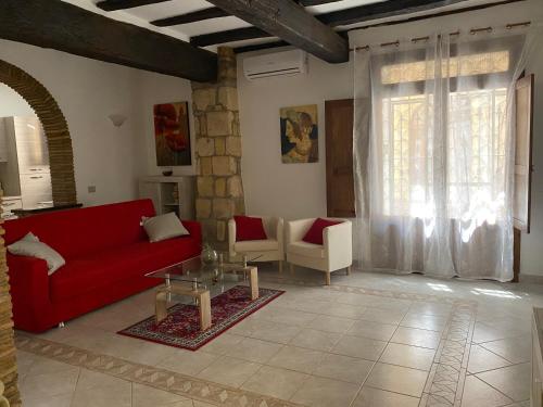 sala de estar con sofá rojo y sillas en La Fanciulla Velca, en Tarquinia