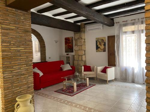 a living room with a red couch and chairs at La Fanciulla Velca in Tarquinia