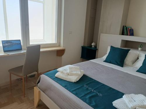 a bedroom with a bed and a chair and a window at GIOSAHOUSE in Uggiano la Chiesa