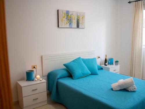 a bedroom with a blue bed with blue pillows at Puesta de Sol Rentals 3AR in Playa de San Juan