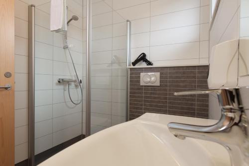 a bathroom with a sink and a shower at Hotel Raudaskrida in Þóroddsstaður