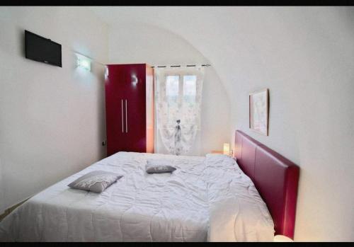 a bedroom with a large bed with a red cabinet at B&B LA CASETTA DI ALICE in Cascia