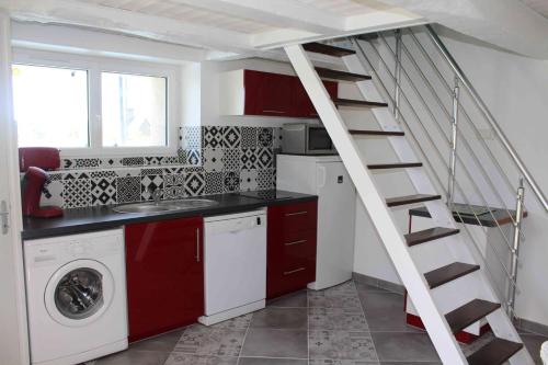 une cuisine avec un escalier et un lave-linge. dans l'établissement Mellé gîte à la campagne proche du Mont Saint Michel, à Mellé