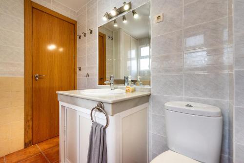 a bathroom with a toilet and a sink and a mirror at apartamento benalmadena in Benalmádena