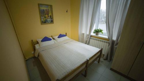 a bedroom with a bed with blue pillows and a window at Митяевский Mityaevskyi Guest House in Kolomna