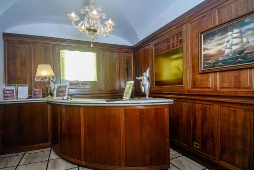 - un bar dans une pièce dotée de murs en bois et d'un lustre dans l'établissement Hotel Regina Margherita, à Rome