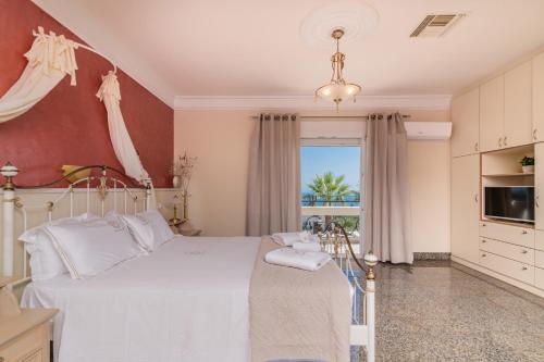 Frido Luxury Villa with Jacuzzi في Akrotiri: غرفة نوم بسرير ونافذة كبيرة
