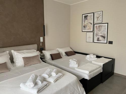 twee bedden in een kamer met witte handdoeken erop bij Liberty Lodge in Tropea