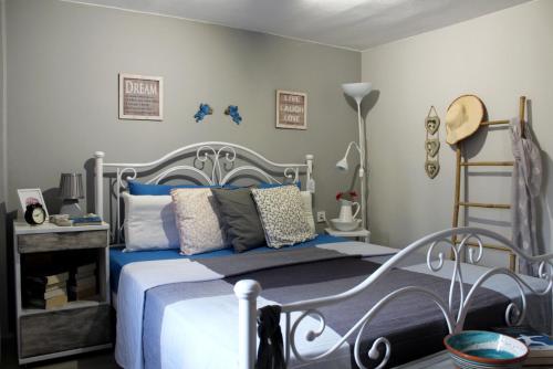 a bedroom with a bed with blue pillows at Cozy house with relaxing backyard in Ermoupoli