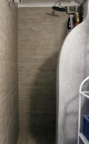 a bathroom with a walk in shower with a tile floor at Cozy house with relaxing backyard in Ermoupoli