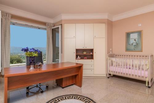 a home office with a desk and a crib at Frido Luxury Villa with Jacuzzi in Akrotiri