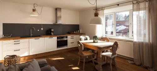 a kitchen with a wooden table and a dining room at Modern-bayrisches Apartment mit Seeblick in Tegernsee