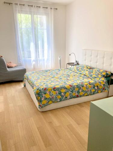 une chambre avec un lit avec un couvre-lit fleuri dans l'établissement Edouard VII, à Menton