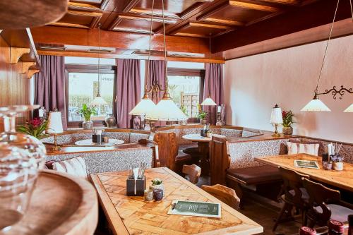 a restaurant with wooden tables and chairs and windows at Boutique-Gasthof Ueberfuhr in Salzburg